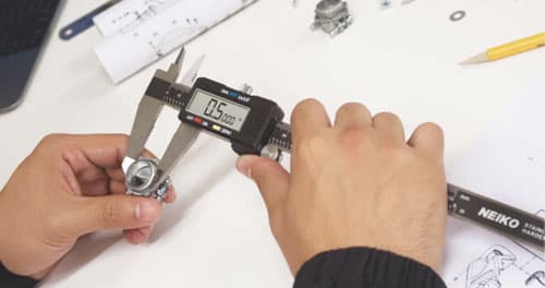 Digital vernier caliper measuring a machined component